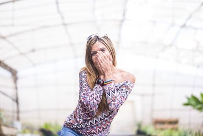 Portrait of beautiful woman standing against blurred background