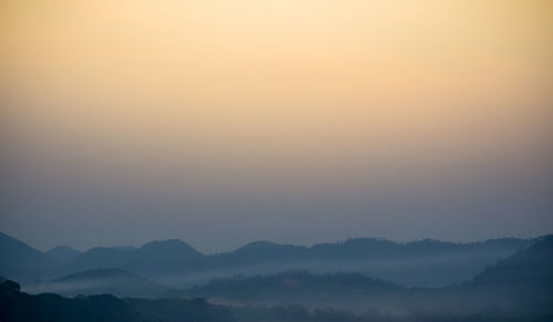 Scenic view of silhouette mountains against sky during sunset