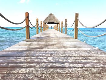 Wooden pier over sea against sky