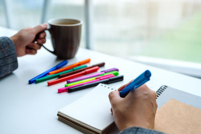 High angle view of women writing on table