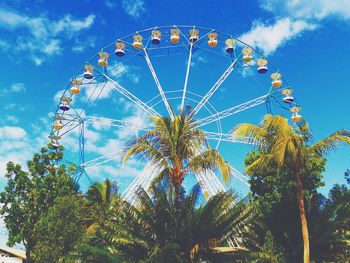 Low angle view of ferris wheel against blue sky