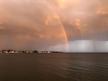 Scenic view of rainbow over sea against sky