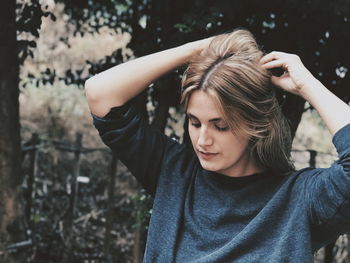 Close-up of young woman against trees