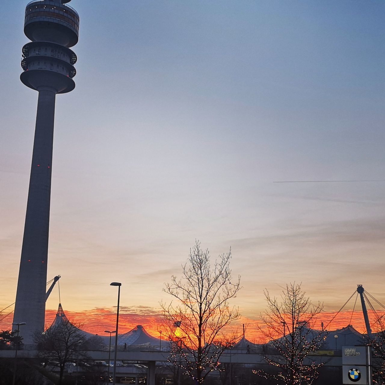 architecture, sky, built structure, building exterior, sunset, low angle view, tower, nature, city, bare tree, no people, tree, building, travel destinations, technology, travel, tourism, tall - high, communication, spire, outdoors, global communications, office building exterior, skyscraper