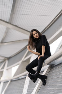 Portrait of young woman sitting on staircase