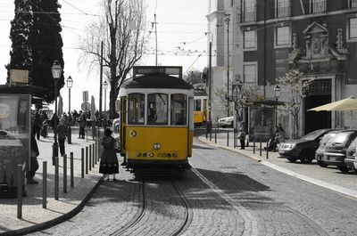 Cars on street in city against sky