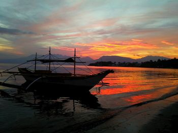 Scenic view of sea against dramatic sky during sunset