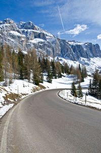 Road amidst snowcapped mountains against sky