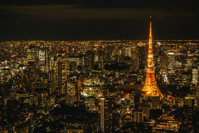 Illuminated cityscape against sky at night