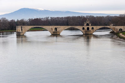 Arch bridge over river against sky