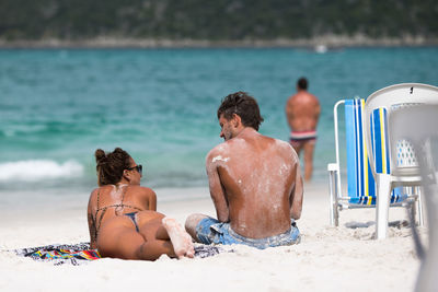 Friends relaxing on shore at beach