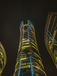 Low angle view of illuminated buildings against sky at night