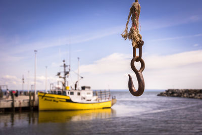 Sailboats moored in sea against sky