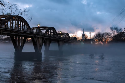 View of bridge over river against cloudy sky