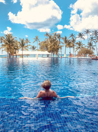 Man swimming in pool against sky