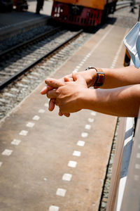 Close-up of person hand on railroad station platform