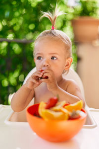 Portrait of cute boy eating fruit