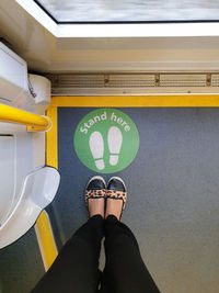 Low section of woman standing on tiled floor