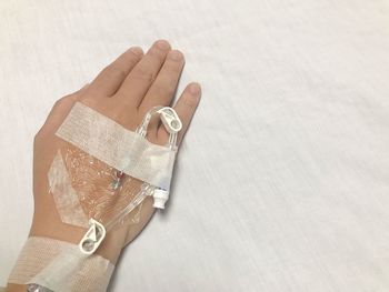 High angle view of hand holding paper over white background