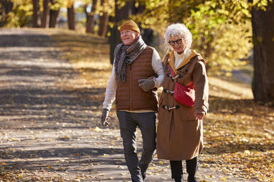 Rear view of couple walking on footpath