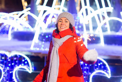 Portrait of smiling woman in snow at night