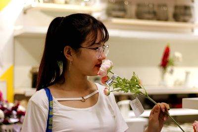 Close-up of young women smelling flower at store