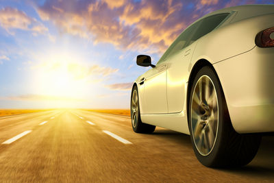 Blurred motion of car on road against sky during sunset