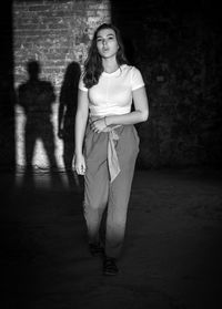 Teenage girl in a dark room and her shadow on the wall