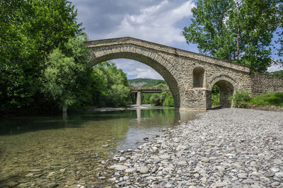 Arch bridge over river against sky