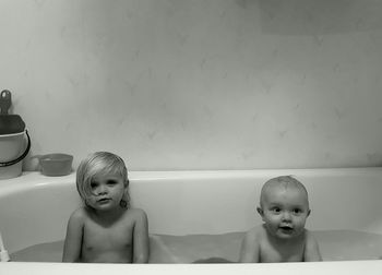 Naked siblings taking bath in bathtub