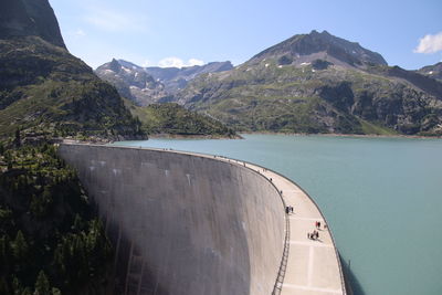 Scenic view of dam and mountains against sky