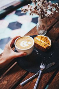 Cropped hand of person holding food on table