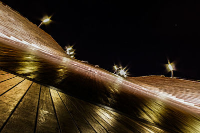 Close-up of illuminated lights against sky at night