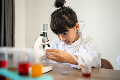 Cute girl using microscope at laboratory