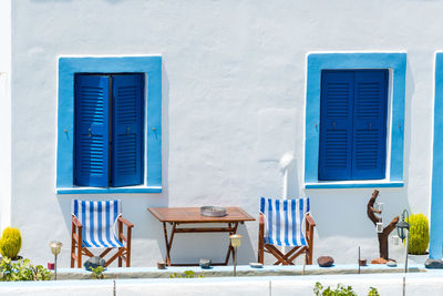 Chairs and tables against blue window of building