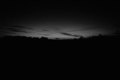 Silhouette landscape against sky at sunset