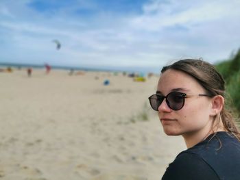 Portrait of young woman wearing sunglasses on beach