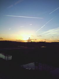 Power lines against sky at sunset