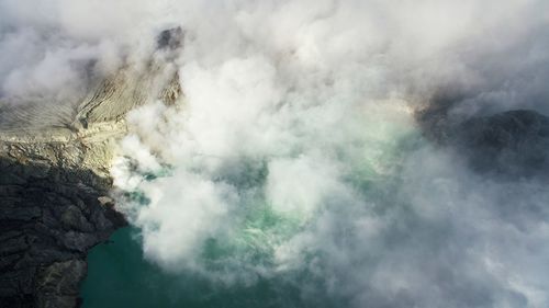 Smoke emitting from volcanic mountain against sky