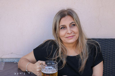 Contemplating mature woman holding beer glass