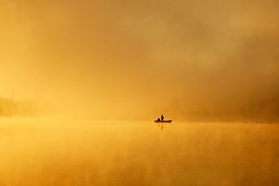 Scenic view of boat on water against sky during sunset