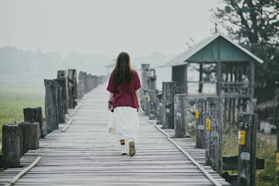 Rear view of woman walking on footpath