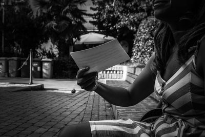 Woman reading book on street