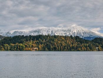 Scenic view of lake bled by mountains against sky.