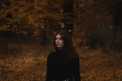 Beautiful woman standing in forest during autumn