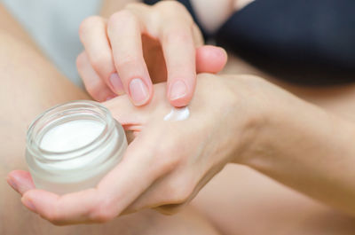 Midsection of woman holding bottle