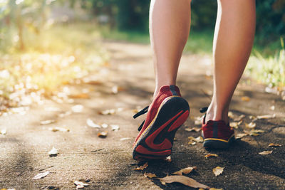 Low section of woman walking on road