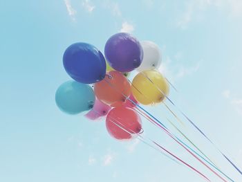 Low angle view of balloons against blue sky