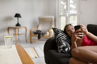 Woman on sofa using cell phone