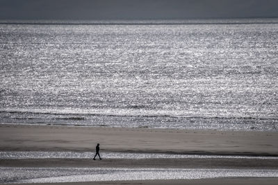 Distant view of man walking at beach